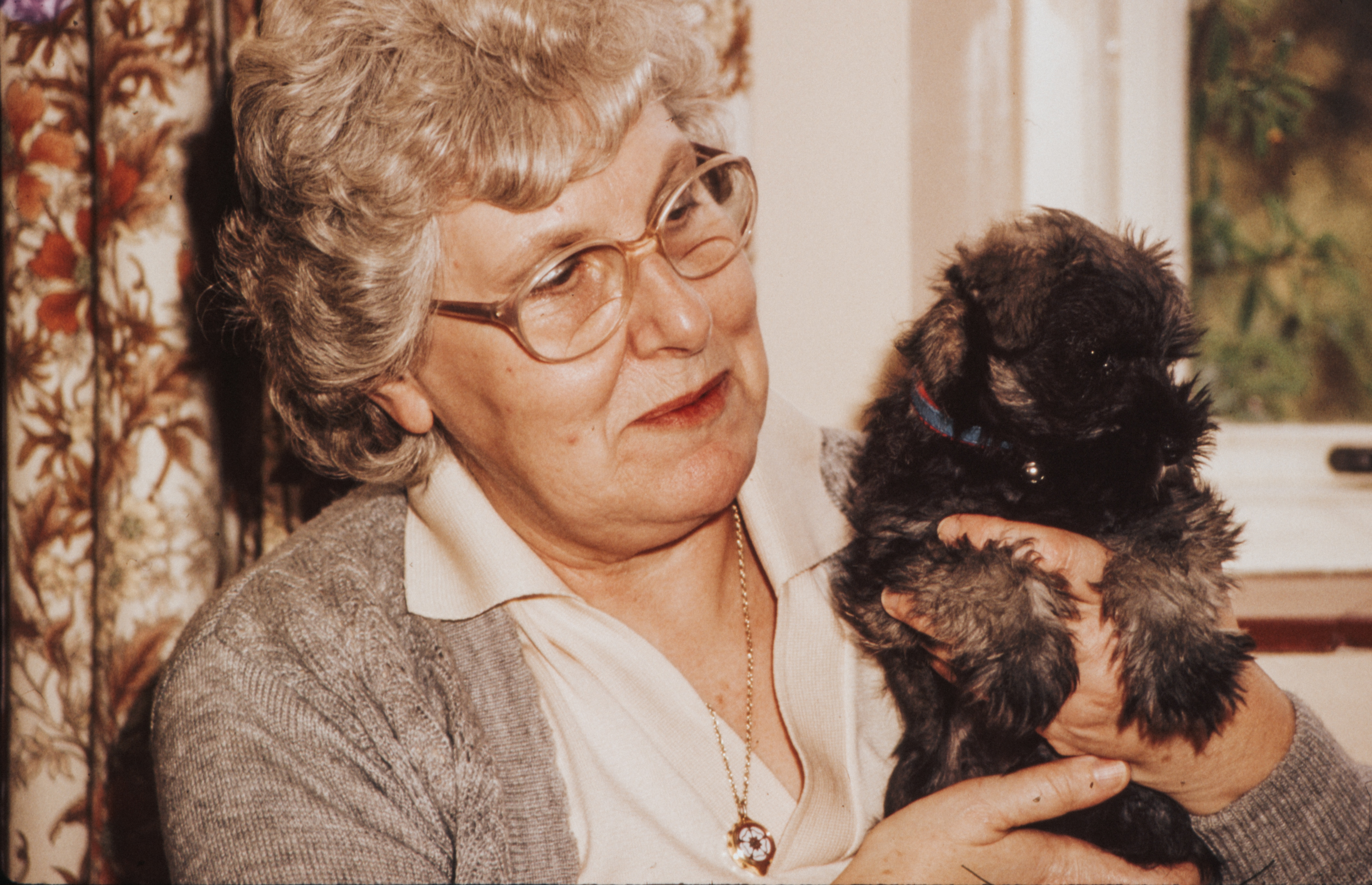 vintage photo of an elderly woman holding a puppy