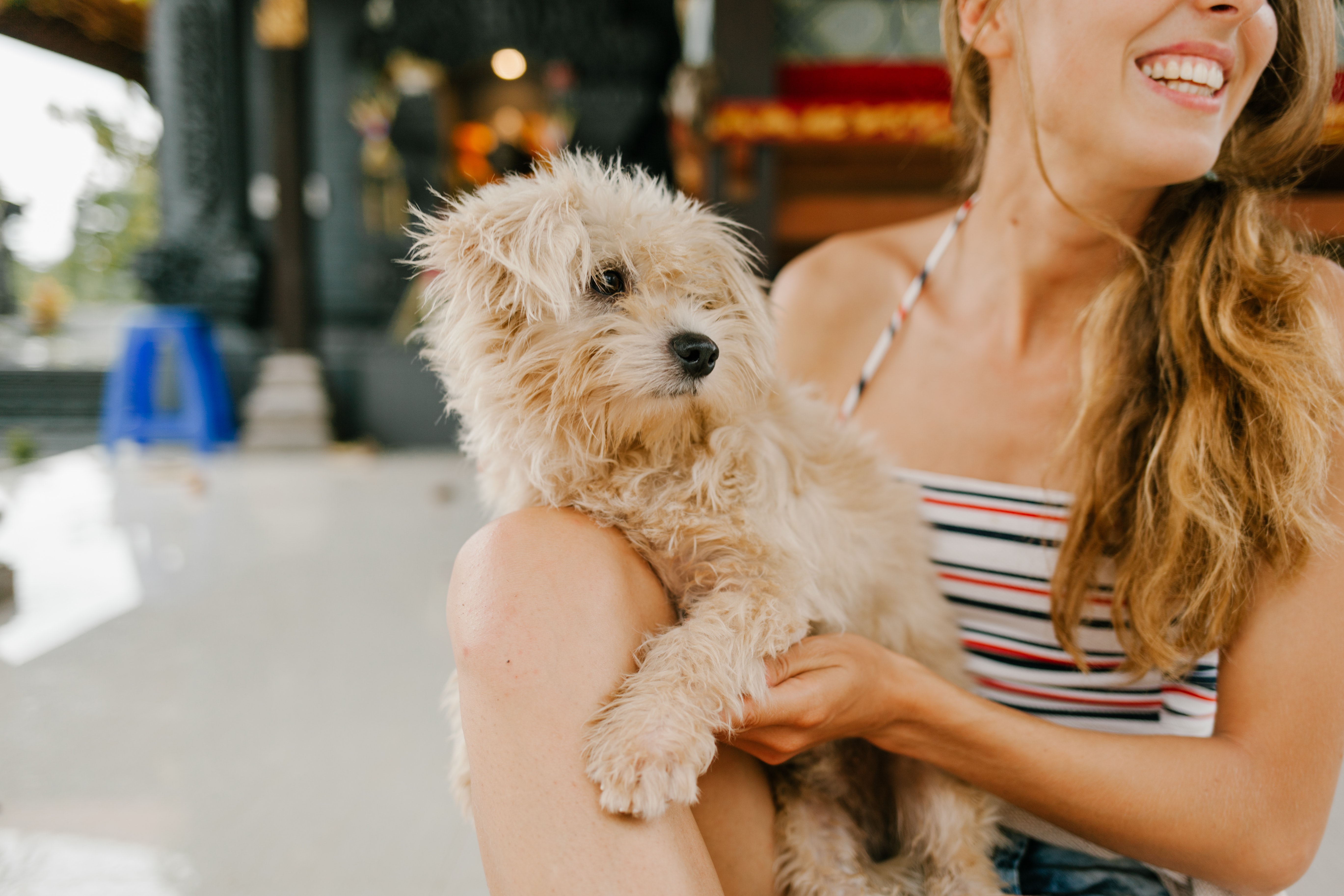 woman holding a dog looking to the side and smiling