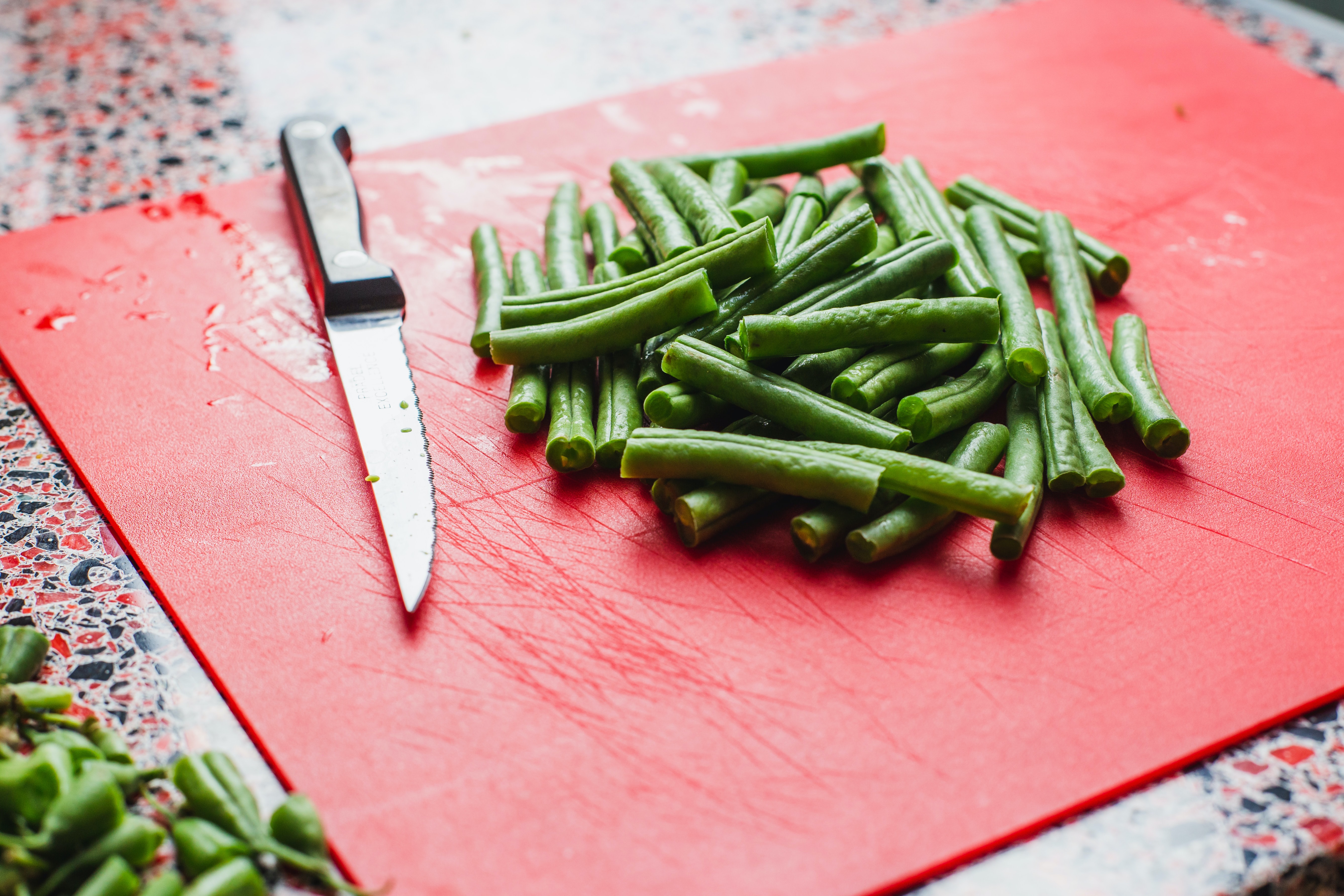 green beans on a red cutting board