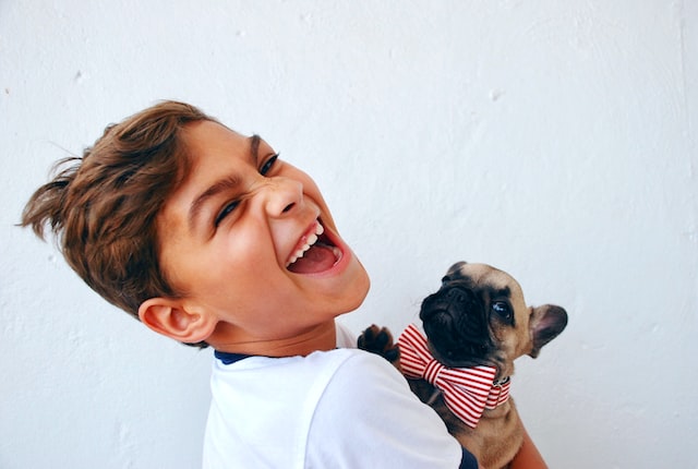 a happy child with a puppy in his arms